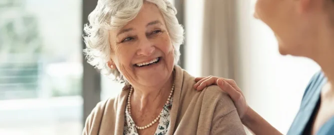 Signs you need memory care: caregiver discussing options with smiling senior woman in memory care community
